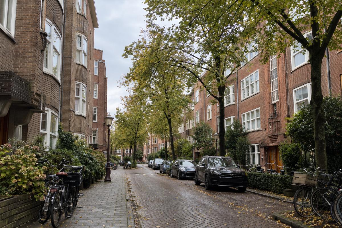 Rustige straat in Amsterdam-Zuid met bakstenen woonblokken uit de jaren dertig, bomen en geparkeerde fietsen